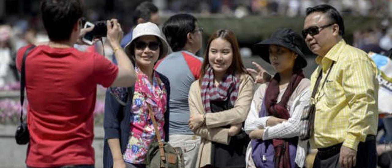Turistas chinos se fotografían en el destino que eligieron para pasar sus vacaciones.