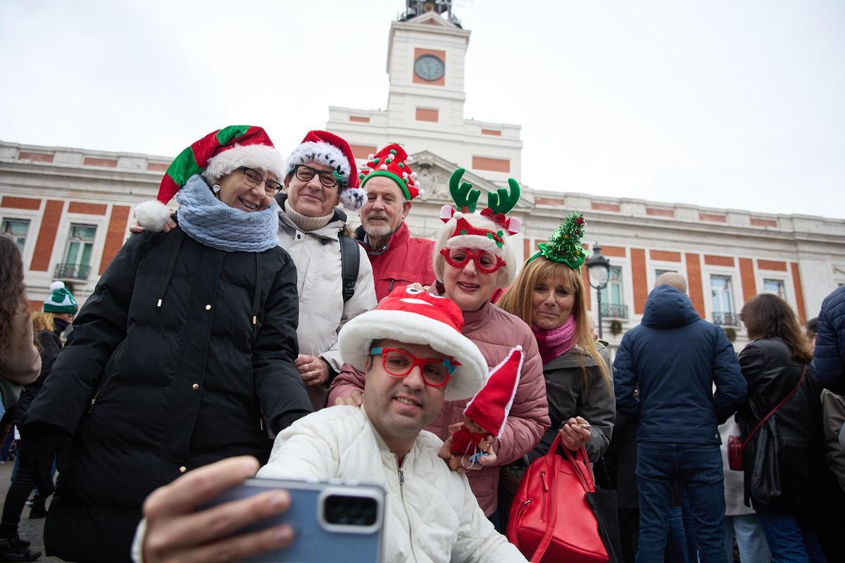 Varias personas celebran las Preuvas en la Puerta del Sol, a 31 de diciembre de 2023, en Madrid (España).