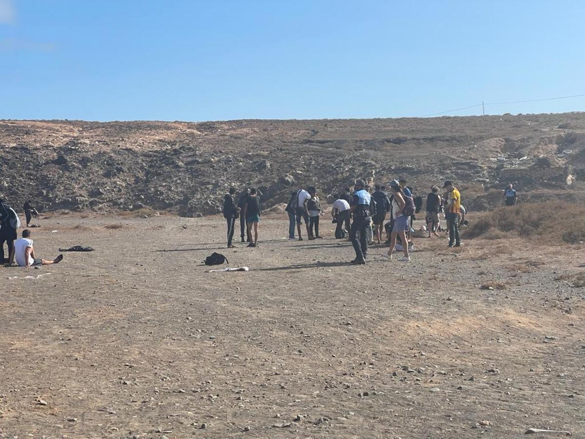 Una pareja de la Policía Local de Haría junto a los migrantes que llegaron este sábado a la playa de La Garita en Arrieta.