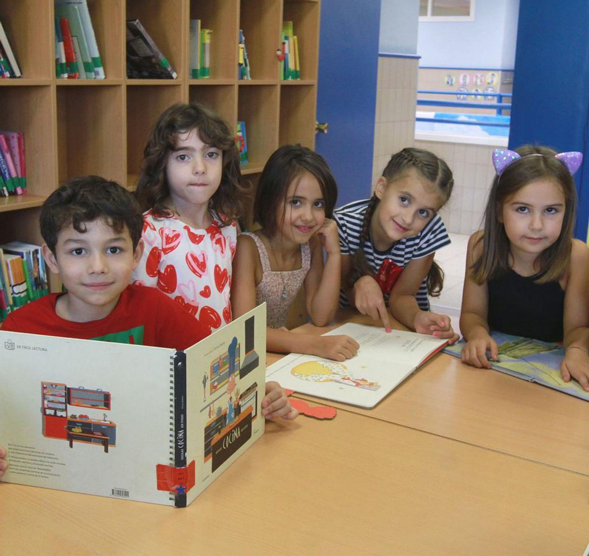 Cinco escolares con varios libros, en la biblioteca.   | // I. OSORIO 