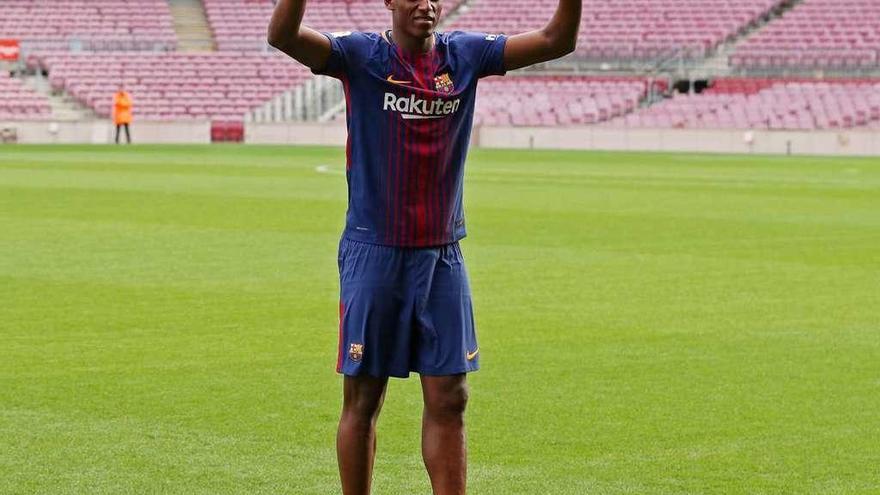 Yerry Mina pisa descalzo el Camp Nou, ayer durante su presentación oficial con el Barcelona. // Albert Gea