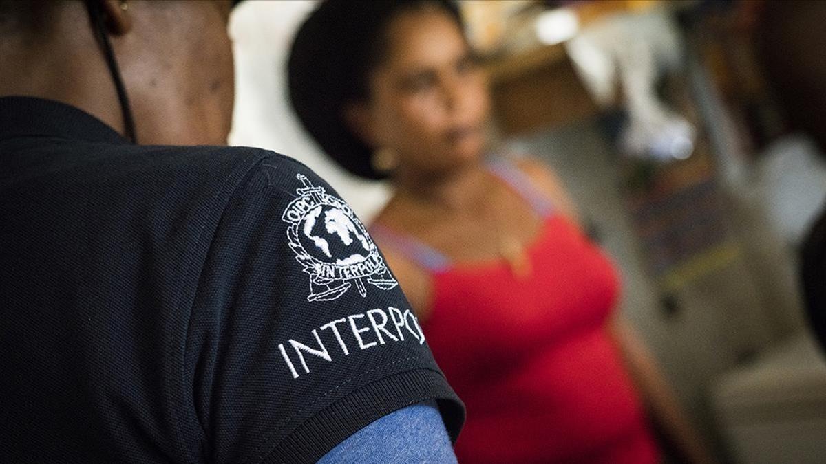 Un agente de la Interpol habla con una de las mujeres forzadas a trabajar como prostitutas junto a una mina de oro en Guyana.