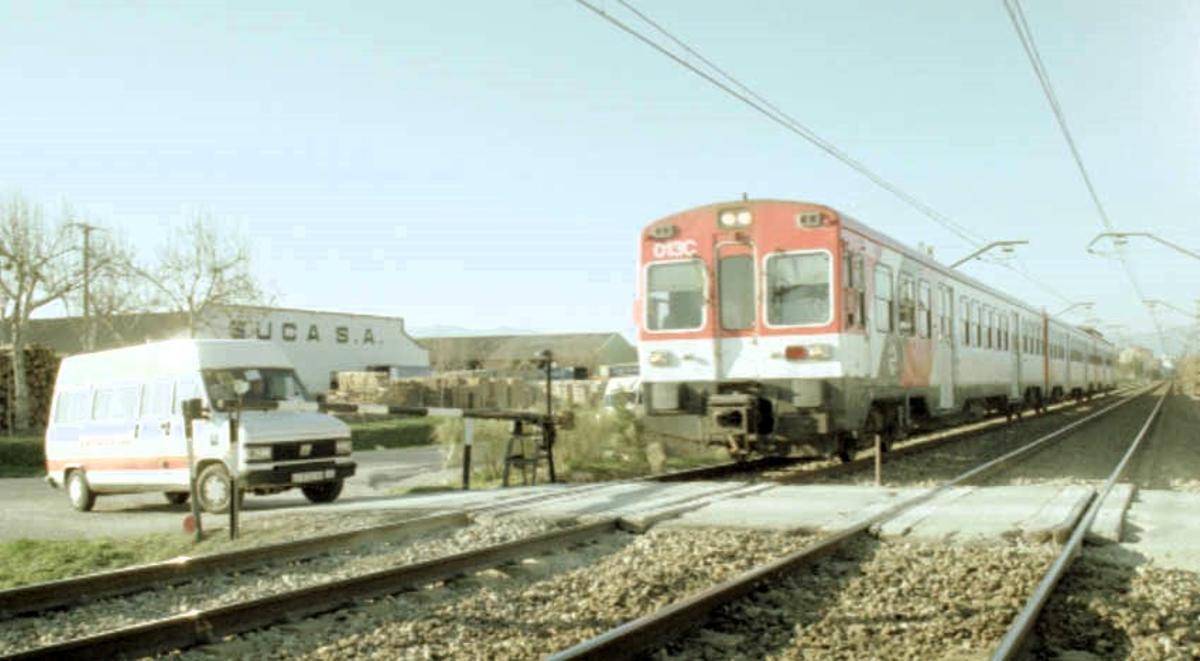 Un bus de transport de passagers esperant en el pas a nivell manual
