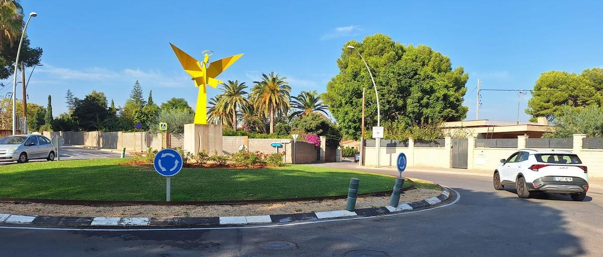La escultura del ángel de la rotonda del cruce de las calles Monestir del Puig y Monestir de Benifassà con Molí Bisbal es ahora plenamente visible con su repintado de color amarillo corporativo.