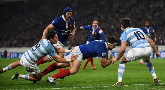 Guilhem Guirado (C) de Francia se sumerge y anota un intento durante el partido de prueba de rugby entre Francia y Argentina en el Estadio Pierre Mauroy en Villeneuve-dAscq.