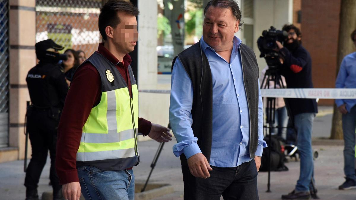 El expresidente del Huesca, Agustín Lasaosa, sale de las oficinas escoltado cuando la Policía registró el club.
