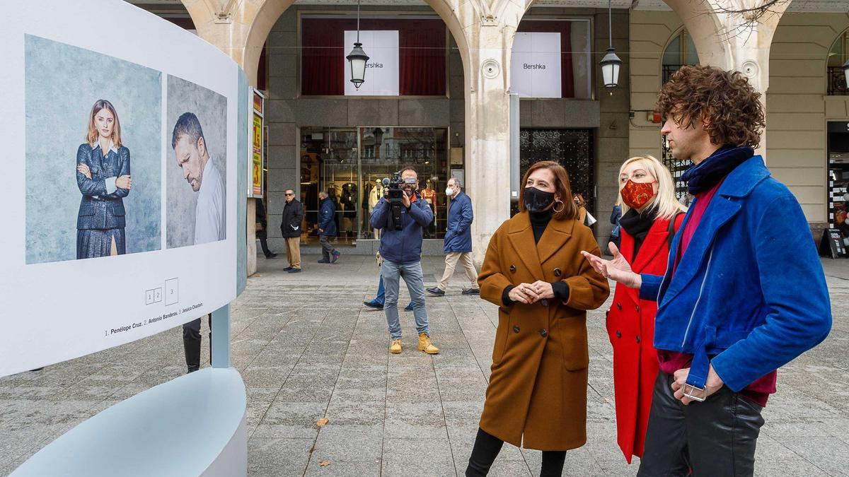 El fotógrafo Jorge Fuembuena enseña los retratos de Penélope Cruz y Antonio Banderas a la vicealcaldesa y a la comisaria de la muestra.