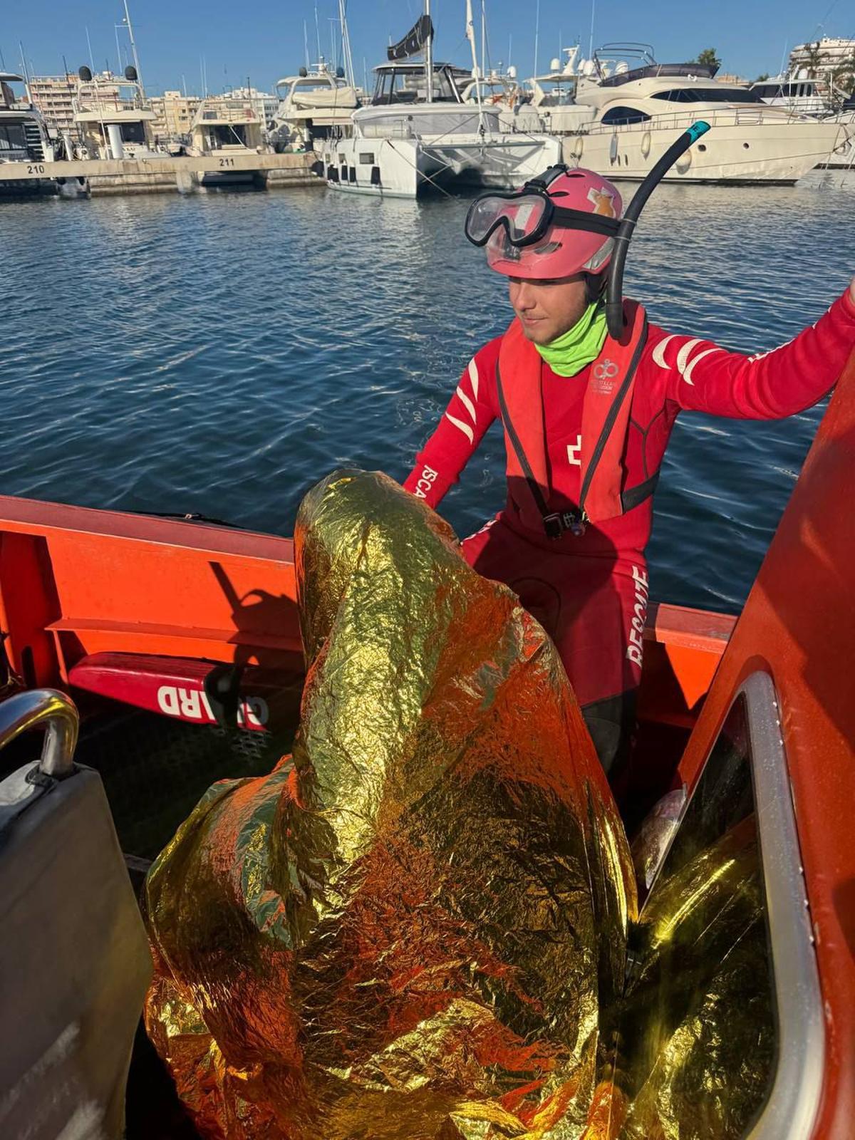 Un miembro de Cruz Roja con el hombre de 37 años rescatado.
