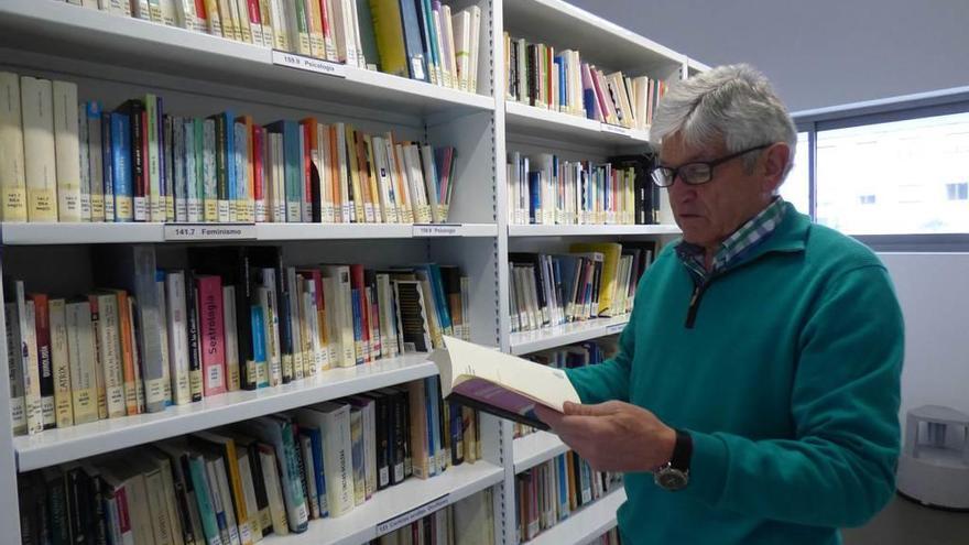 Santiago Marín mirando ayer unos libros en la biblioteca de la Pola.