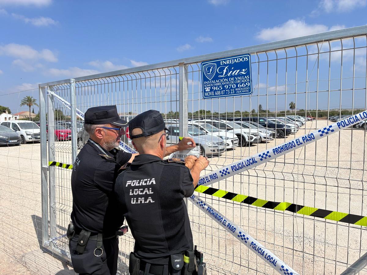 Los agentes de la Policía Local, poniendo el precinto en la campa de Torrellano.