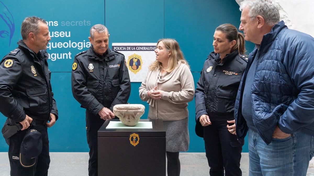 Policías y personal de Patrimonio, con la pieza.