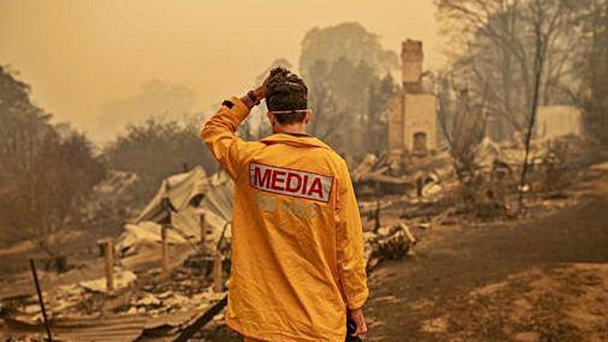 Un fotògraf observa la devastació causada pels incendis.