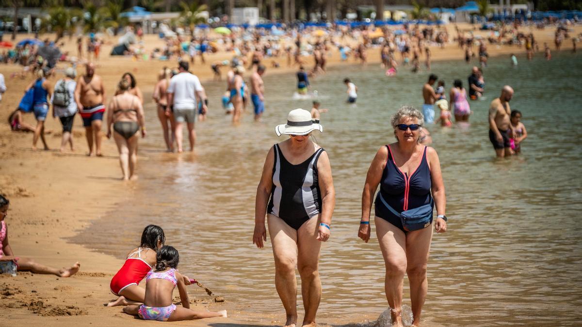 Varias personas pasean por la orilla de las playas de Las Teresitas