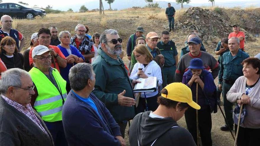 La Guardia Civil informa a los vecinos una vez concluido el rastreo con el hallazgo de restos humanos.