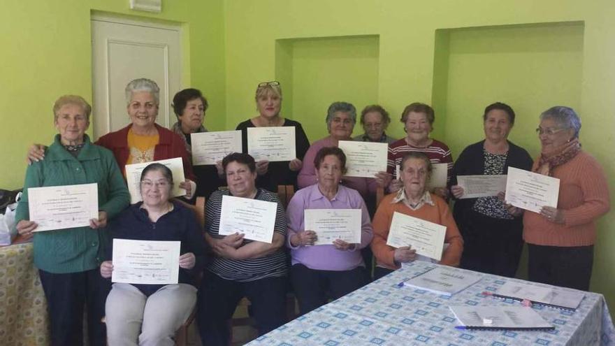 Mujeres de Santa Colomba de las Monjas posan con los diplomas del taller de memoria.