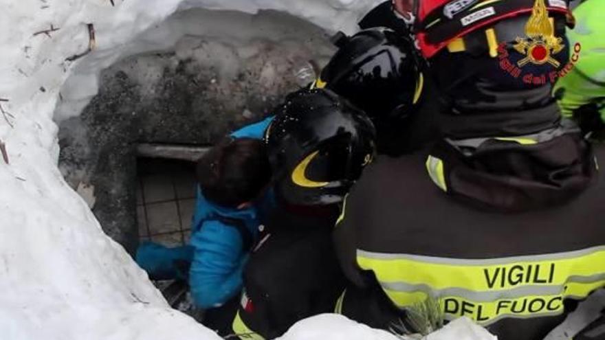 Els serveis de rescat extreuen un dels nens supervivents d&#039;un forat a la neu a sobre de l&#039;hotel.