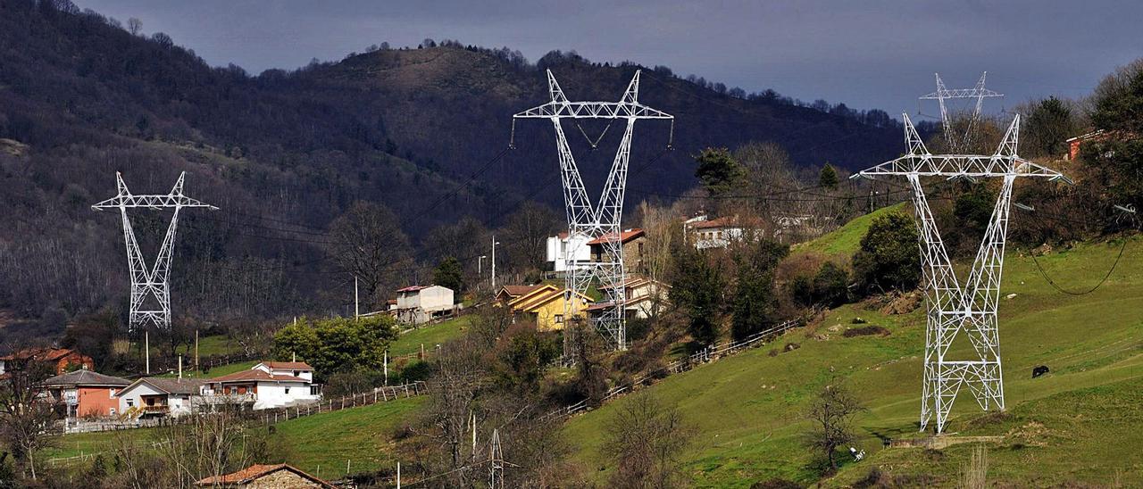 Instalaciones de una línea eléctrica en terrenos de la zona rural de Lena.