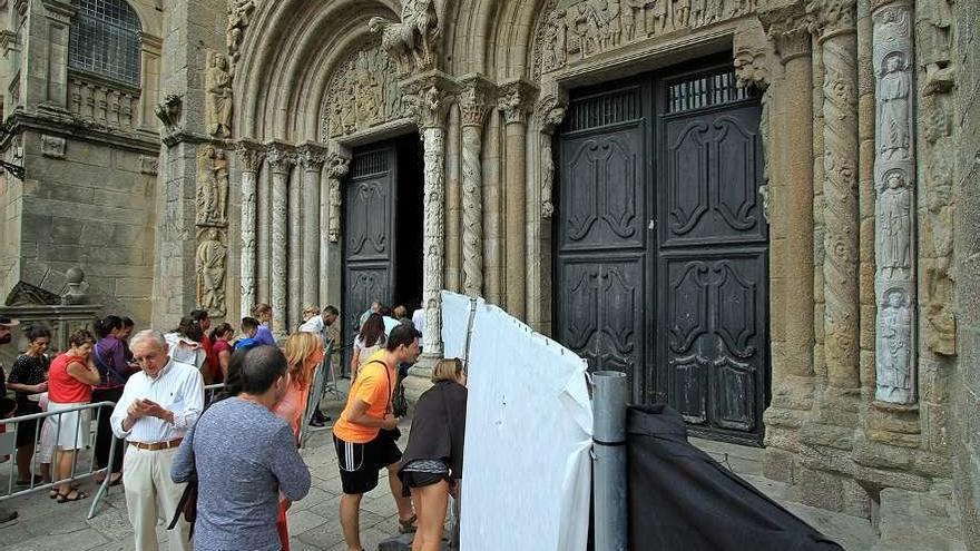 Varios visitantes se asoman ayer para ver la figura, protegida con una valla, en Santiago.