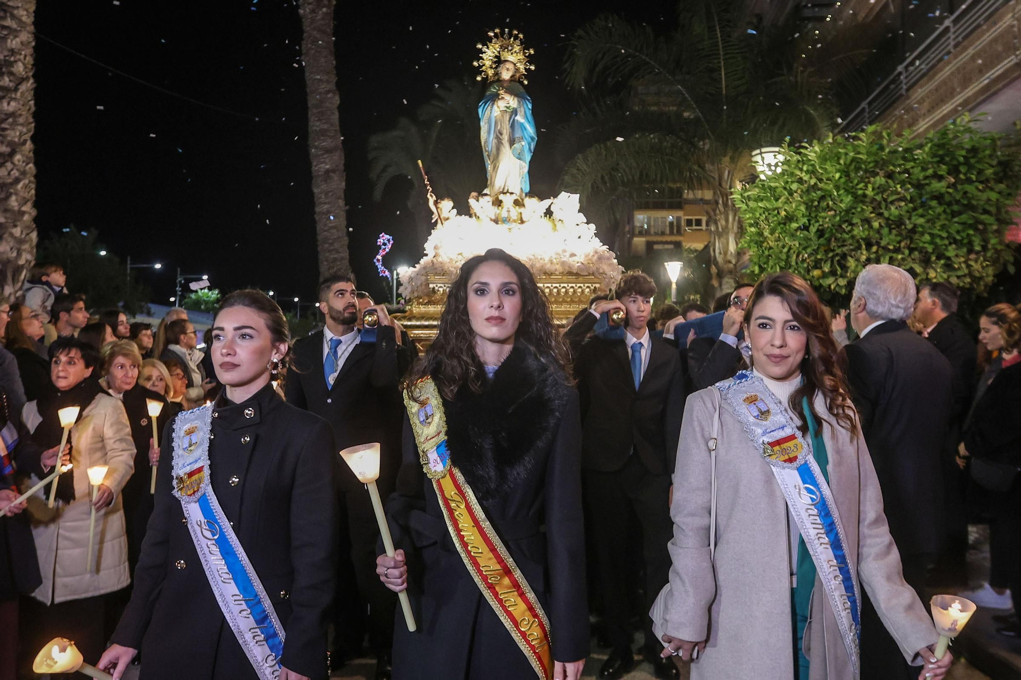 Mireya Hernández Gómez, Reina de la Sal y las damas Paula García Mañogil y Beatriz Cerdá Prado junto a la imagen de la Purísima a su paso por el Casino