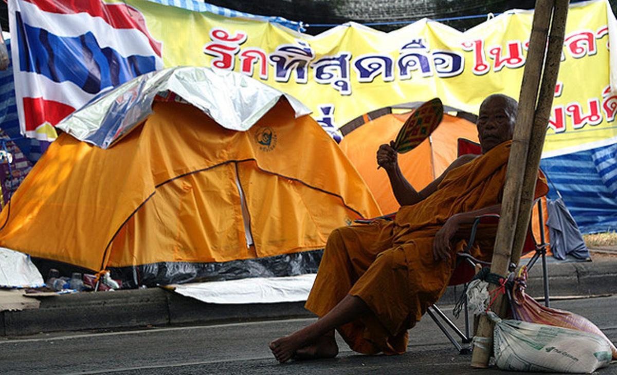 Un monjo budista és fotografiat a les carpes dels seguidors de l’Aliança del Poble per a la Democràcia (APD), coneguts per ’camises grogues’, que segueixen acampats als voltants de la seu de l’Executiu per demanar més duresa al Govern contra Cambodja, a Bangkok, Tailàndia. Els ’camises grogues’ volen que es revoqui un acord fronterer vigent des de fa una dècada per reclamar la sobirania sobre el temple fronterer de Preah Vihear, que els dos països es disputen.