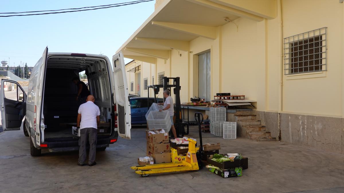 Los trabajadores descargan algunos de los alimentos que han recibido.