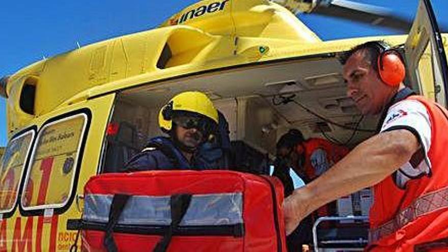 Tripulantes y personal sanitario suben a un helicóptero del 061.