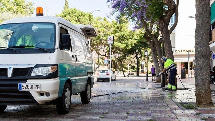 Un operario baldea una de las calles de Marbella.