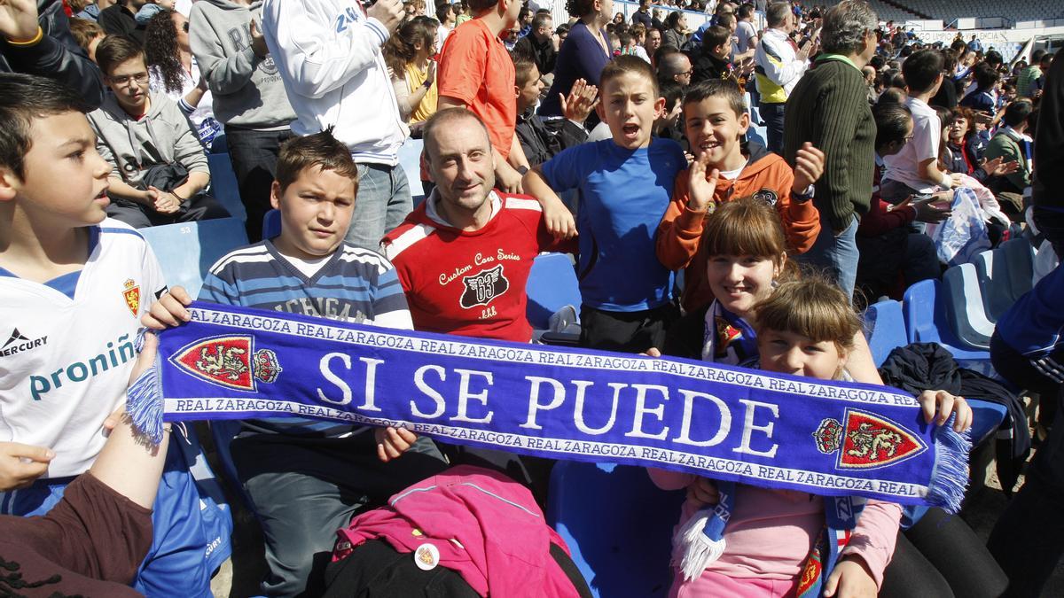 Aficionados del Real Zaragoza posan con una bufanda del club en una imagen de archivo