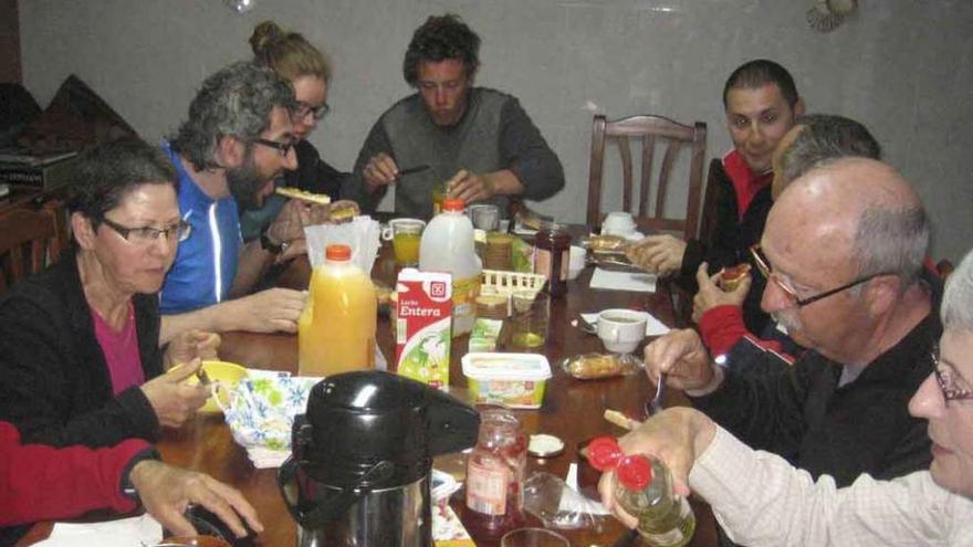 Un grupo de peregrinos desayuna en el albergue de Tábara.