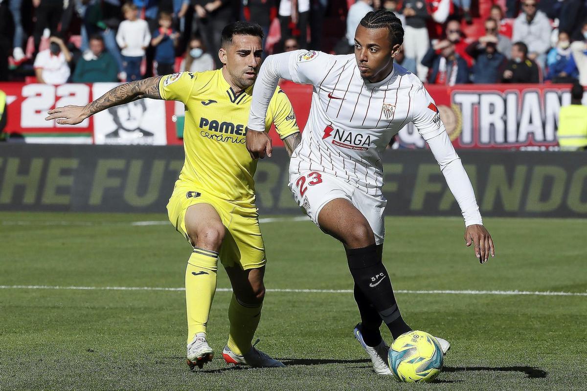 GRAF8709. SEVILLA, 04/12/2021.- Koundé (d), del Sevilla FC y Paco Alcácer del Villareal durante el partido de liga disputado este sábado en el estadio Sanchez Pizjuan en Sevilla. EFE/Jose Manuel Vidal.