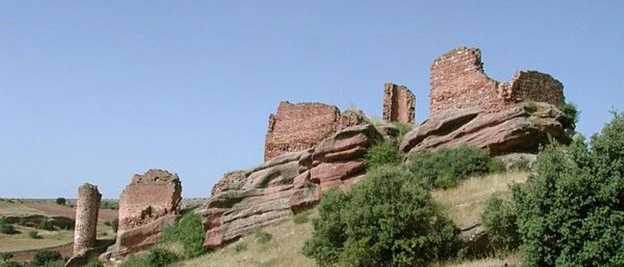 El castillo, del siglo XII, está construido con piedra de rodeno sobre un cerro en mitad del campo.