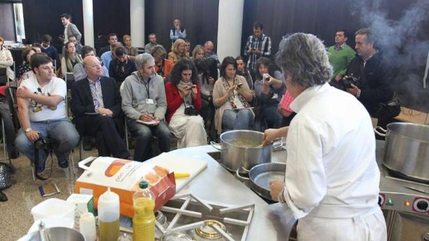 Los blogueros, sentados con el alcalde, durante una muestra de cocina gallega en el auditorio. // I. Osorio