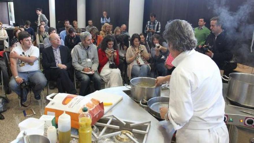 Los blogueros, sentados con el alcalde, durante una muestra de cocina gallega en el auditorio.  // I. Osorio