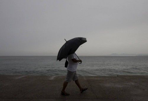 A man holding an umbrella walks along the city's historic boardwalk as Hurricane Patricia approaches the Pacific beach resort of Puerto Vallarta, Mexico