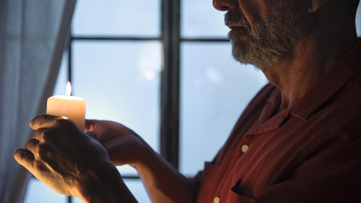 Un hombre sostiene una vela encendida en su casa tras un apagón