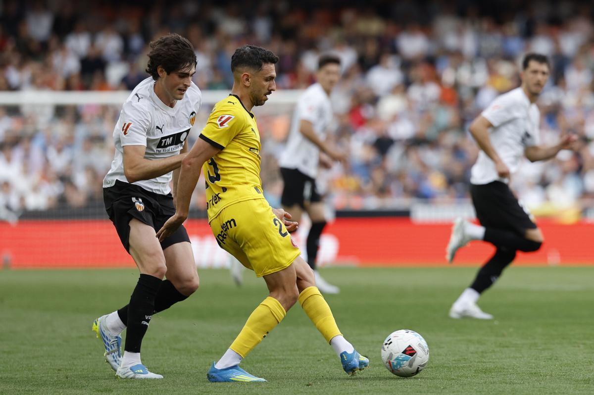 El centrocampista del Valencia Javi Guerra (i) disputa un balón con el centrocampista del Girona Iván Martín (d) durante el partido de LaLiga entre Valencia CF y Girona FC celebrado este sábado en el estadio de Mestalla, en Valencia. EFE/ Ana Escobar. (VALENCIA) (GIRONA)
