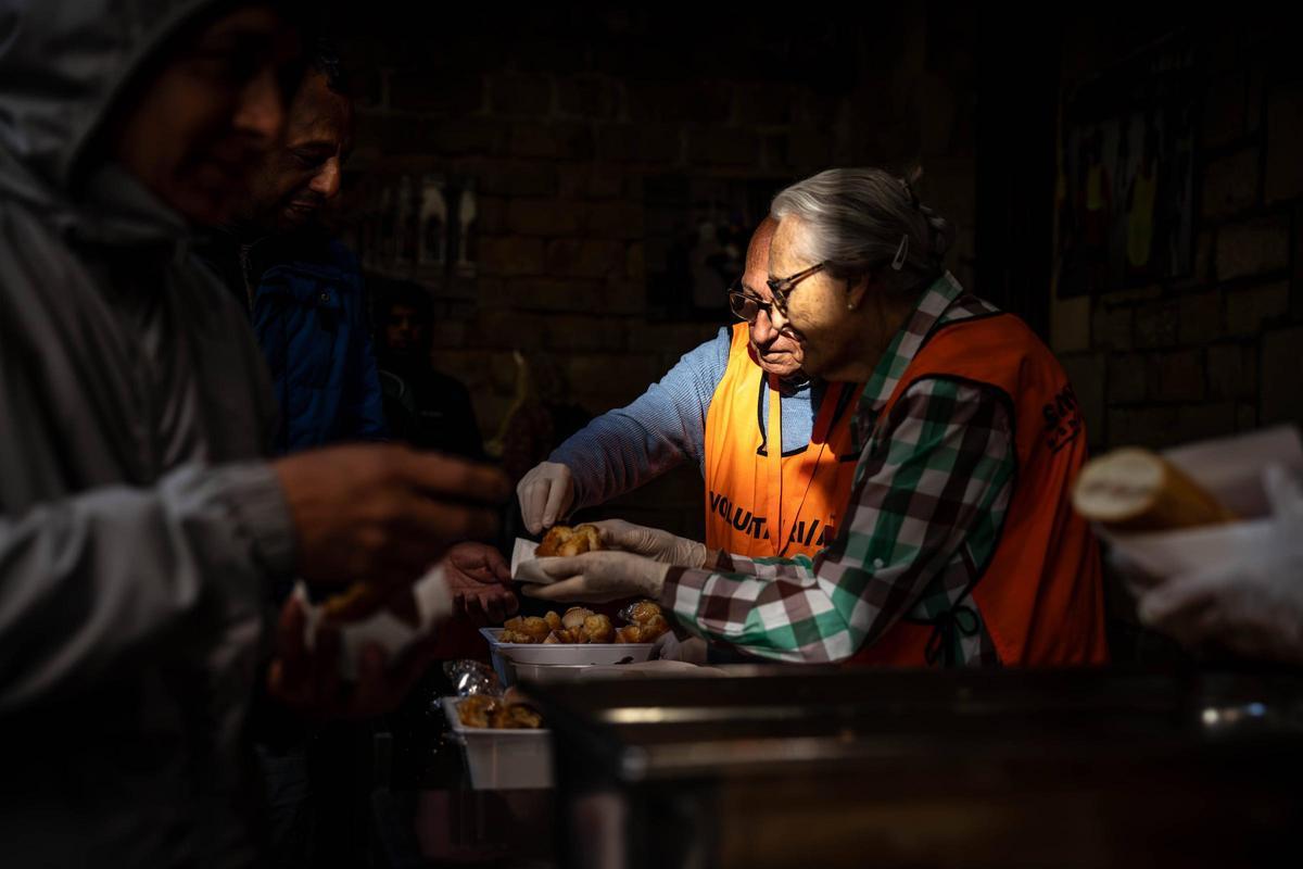 Voluntarias y voluntarios empiezan a servir el desayuno.