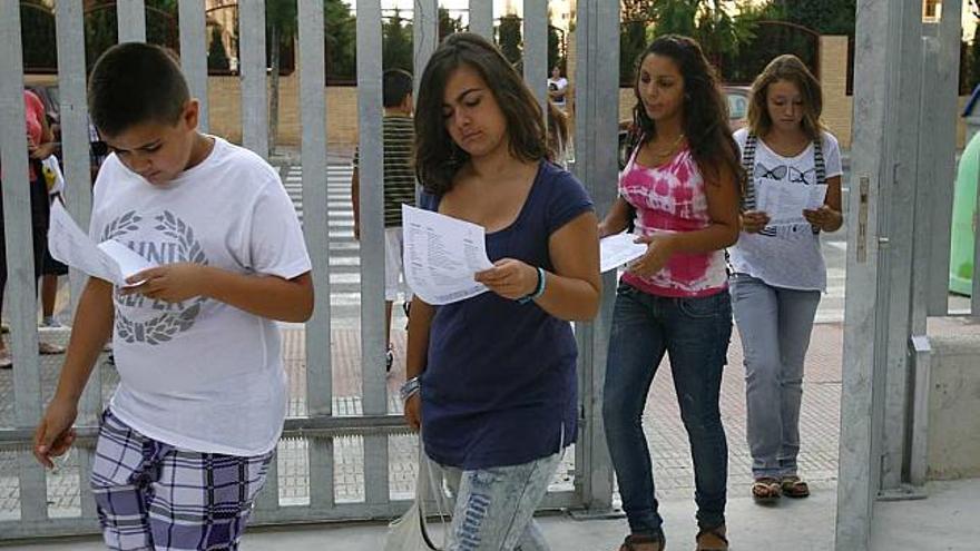 Alumnos del Instituto Bahía de Babel de Alicante revisan los horarios en su vuelta a clase.