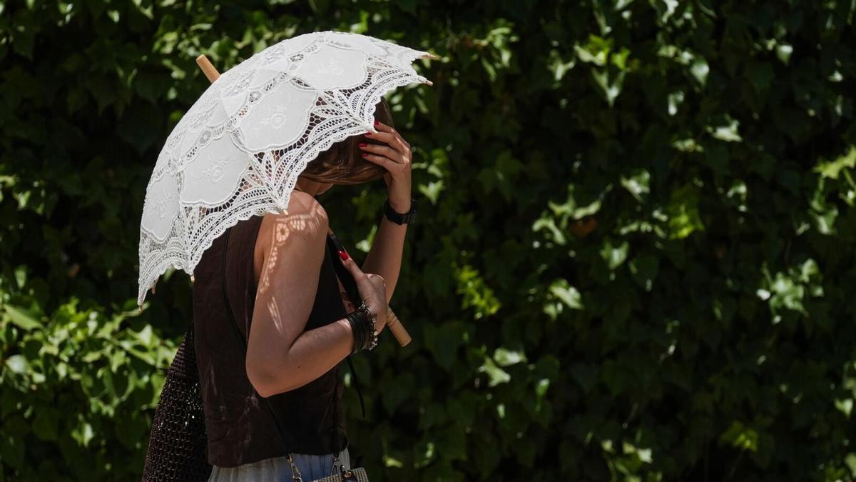 Turistas se protegen del calor por las calles de Sevilla.