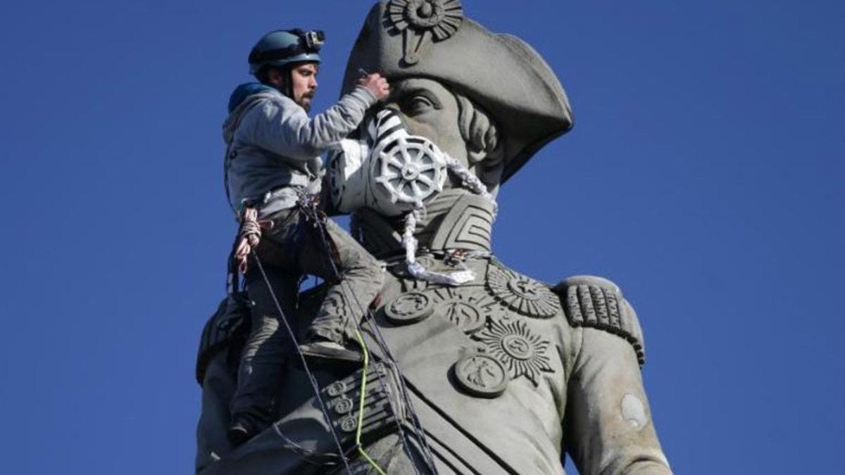 El ecologista Luke Jones poniéndole una mascara a la estatua de Lord Nelson este lunes en Londres.