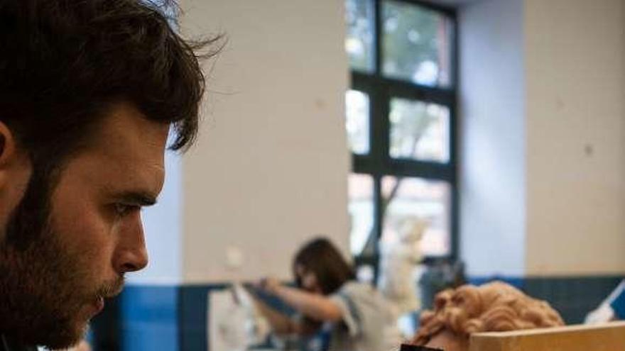 Un joven ultima los detalles de su escultura.