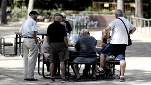 Archivo - Varios pensionistas juegan al dominó en un parque de Madrid.