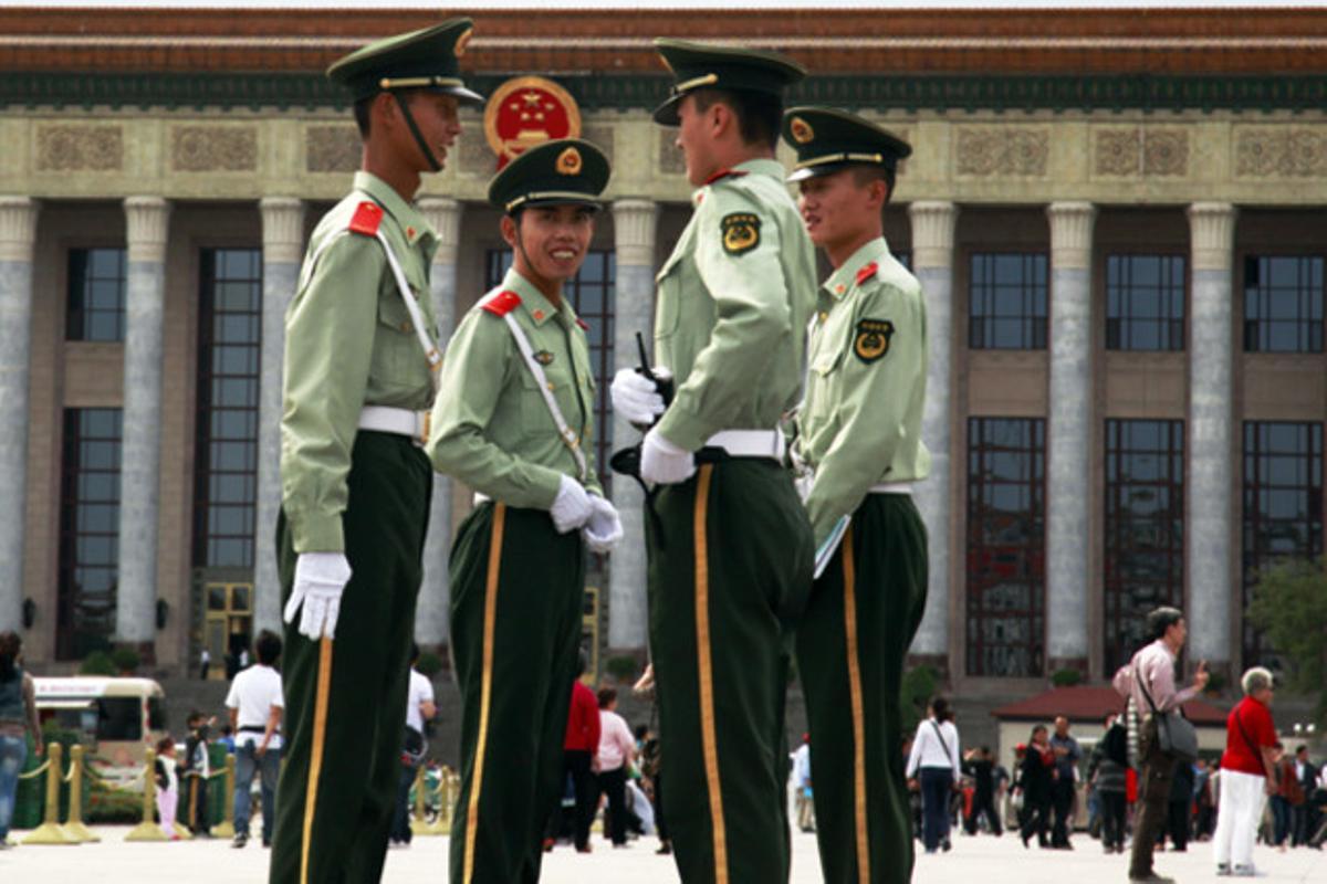 Agents de policia paramilitar xinesos parlen al costat de la Gran Muralla Xinesa a Pequín.