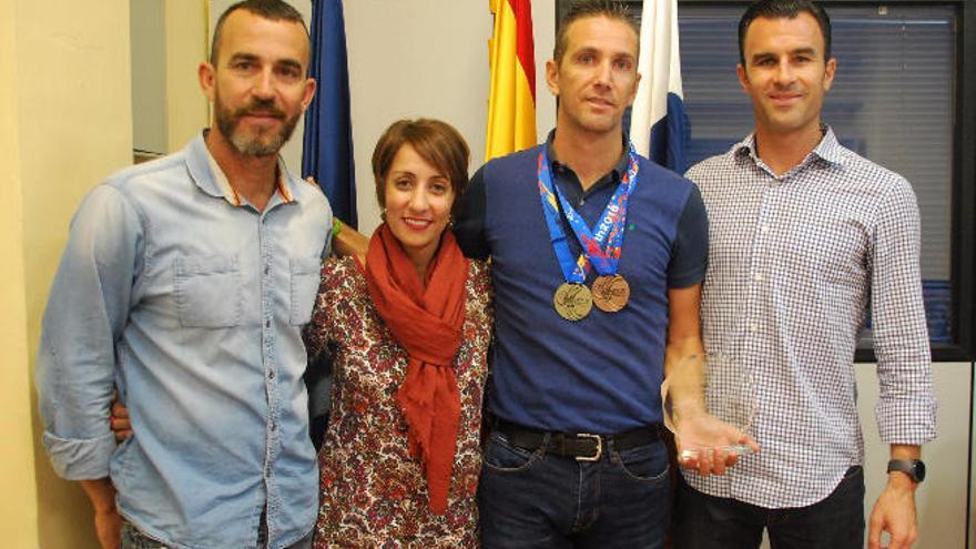 El deportista asturiano afincado en Mogán flanqueado por la alcaldesa y concejal de deportes.