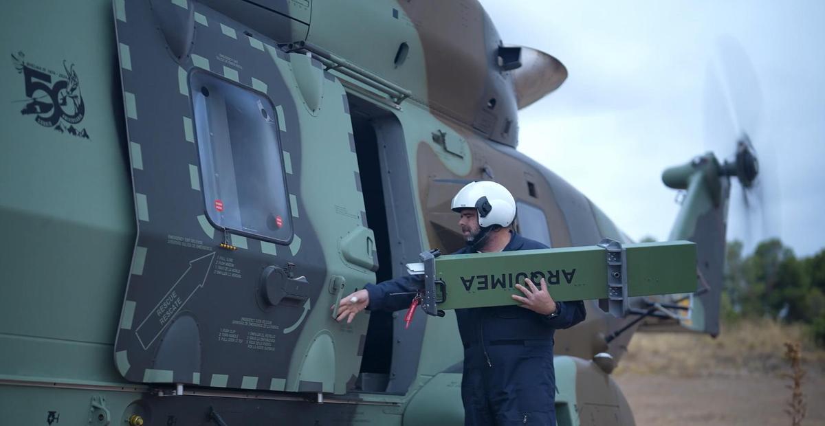 Un técnico de Airbus carga en un helicóptero militar NH90 munición merodeadora antitanque de Arquimea
