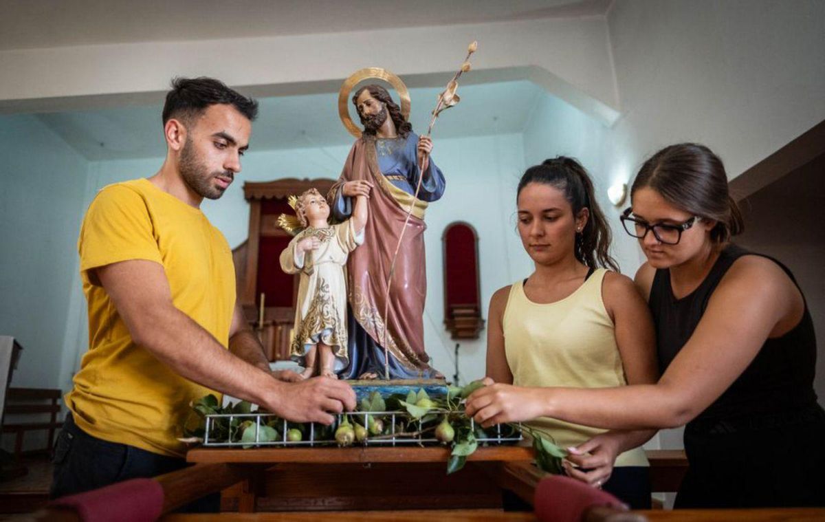 José Morales, junto a dos amigas de Isora, ponen las peras a San José. | A. GUTIÉRREZ