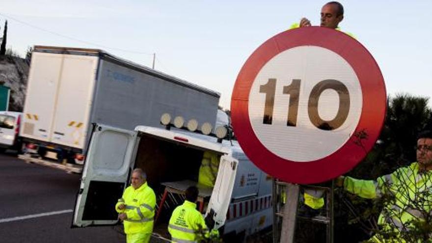 Operarios con la nueva señal de 110 km/h.