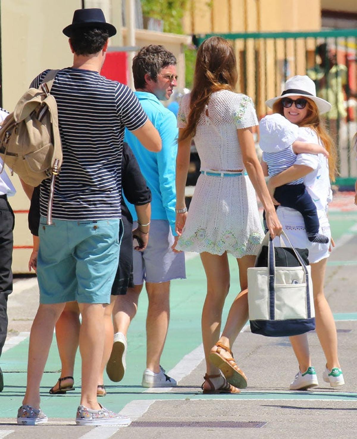 Sacha Baron Cohen, Noel Gallagher, Isla Fisher con el niño en brazos de camino al helicóptero