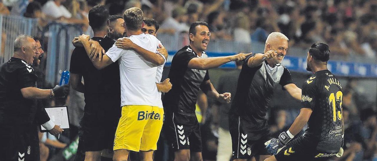 Álvaro Valles -derecha- festeja el segundo gol de la UD en Málaga con Álex García, segundo entrenador, y con José Esteban Yepes, técnico de porteros, que le señala