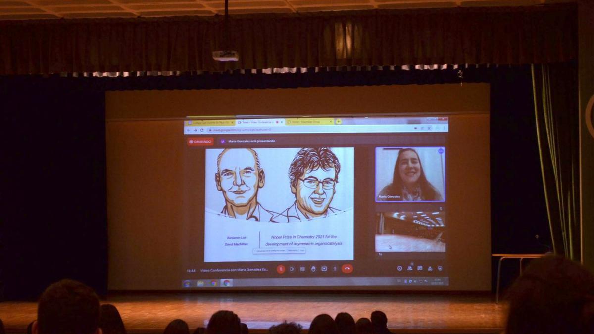 En la pantalla, la benaventana María González Esguevillas junto a los retratos de los Premio Nobel de Química. | E. P.